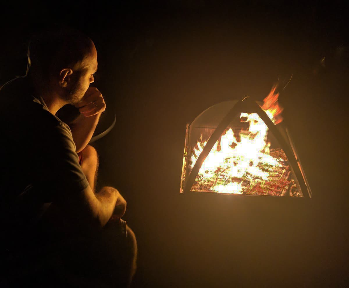 Sitting next to a fire at night